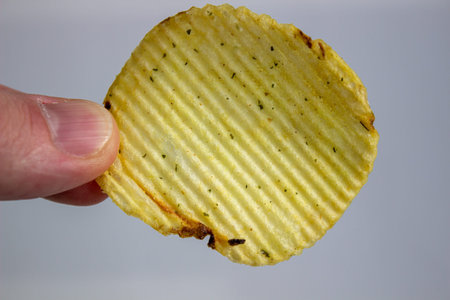 hand holding Potato chips isolated on white background.