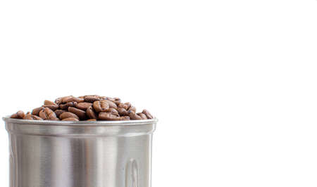A lot of coffee beans in a metal coffee grinder on a white backgroundの写真素材