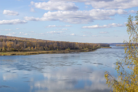 Beautiful, wide river autumn among the woods. Calm and quiet place with autumn colors. In the middle...