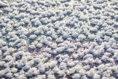 Ice crystals and white snowflakes near the water in winter.の写真素材
