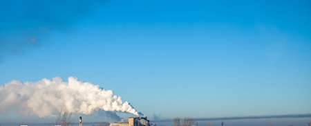 White thick smoke from the boiler room chimney. Smoke against the blue sky. Air pollution. Heating...