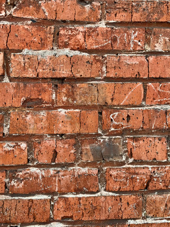 Old red brick wall. The bricks are laid in rows. Grunge stone texture.