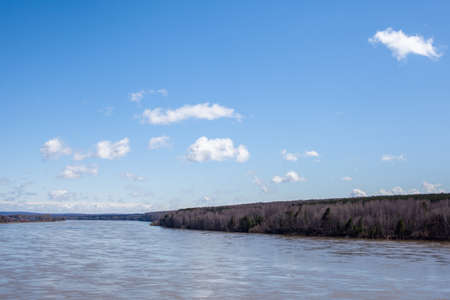 A beautiful, wide river in the spring among the forests. Quiet and peaceful place. Not clear, muddy water in the river. Top view of the distanceの写真素材