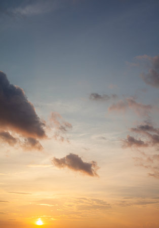 Colorful sunset or sunrise in the sky. The sky and clouds are painted in different bright orange,...
