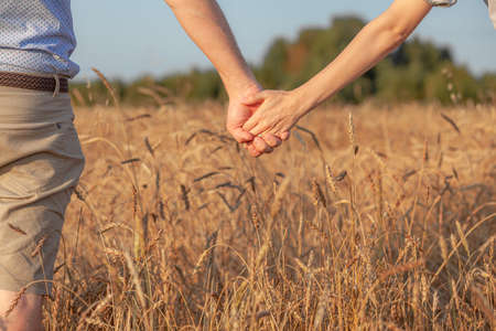 A couple holding hand during sunset, a symbol of love and happyの写真素材