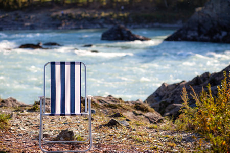 Folding chairs on the bank of a mountain river on a nice, warm day. A calm and quiet place to relax...