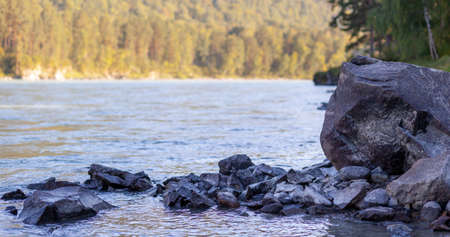 A fast-flowing wide and full-flowing mountain river.の写真素材