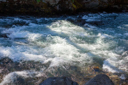 A fast-flowing wide and full-flowing mountain river.の写真素材