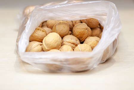 A lot of whole walnuts in a bag on a white background. Healthy foodの写真素材