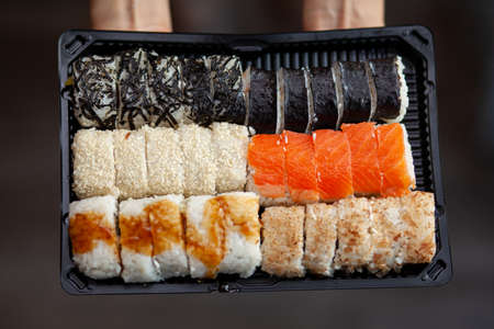 Making sushi and rolls at home. Sushi with seafood, salad and white rice. Food for family and friends. A set of different rolls and sushi on a tray.の写真素材