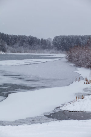 A frozen lake or river in winter. Near the forest and mountainsの写真素材