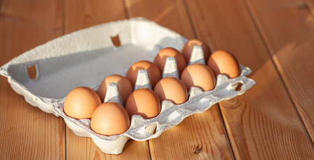 A few brown eggs among the cells of a large cardboard bag, a chicken egg as a valuable nutritious...