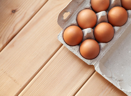 A few brown eggs among the cells of a large cardboard bag, a chicken egg as a valuable nutritious...