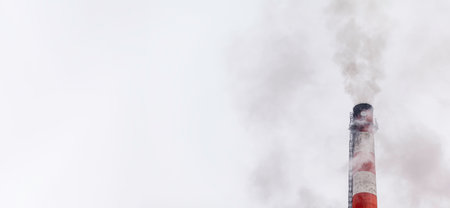Banner. White thick smoke from the boiler room chimney. Smoke against the blue sky. Air pollution. Heating of the city. Industrial zone.の写真素材