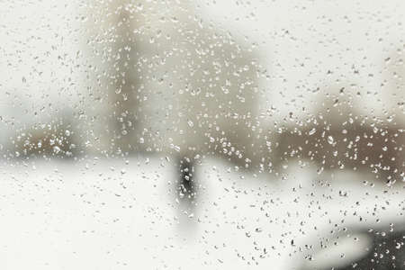 Drops of water on the glass of a car in winter, spring or autumn. The snow melts into drops on the stele of the car. View of the side window of the car from inside the car with condensateの写真素材