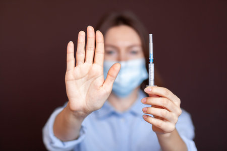 Coronavirus concept. Girl wearing mask for protection from disease and show stop hands gesture for...