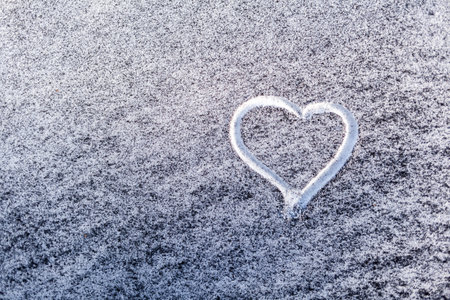 Black soot from the boiler room on white snow. natural background. Snow mixed with coal soot, poor ecology. environmental pollution. A heart is painted on the snow. The importance of protecting natureの写真素材