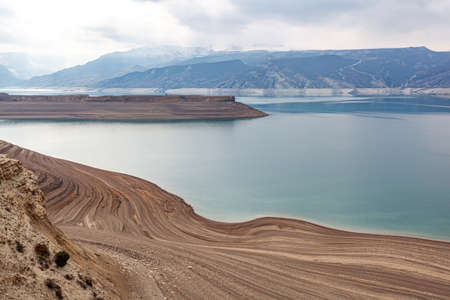 A beautiful reservoir in the mountains. Low water level, droughtの写真素材