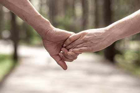 The husbands flour holds his wifes hand tightly in close-up.の写真素材