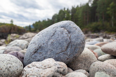 Large stones of different shapes on the riverbank close-up. there are a lot of small stones nearby.の写真素材