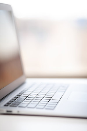 Close-up of the keyboard of an open laptop ready to work on the table. Side view, selective focus on the keyboard. The concept of computer security and work on the Internet.の写真素材