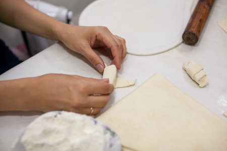 The process of making homemade croissants and other pastries at home. The family is cooking dessert together in the kitchen.の写真素材