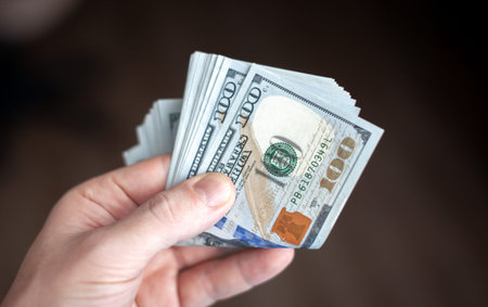 Close up male hand Counting and holding money us dollar. The concept of financial business and...