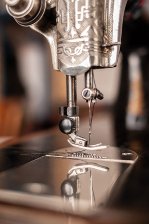 Old sewing machine stands on the table at home ready to work and sew.
