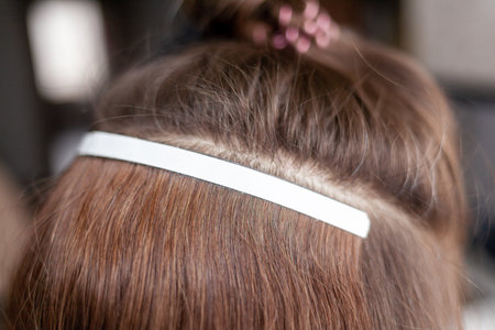 Hair ribbons for extensions on a womans head at home.の写真素材
