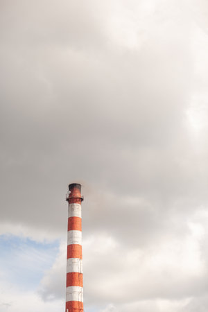 White thick smoke from the boiler room chimney. Smoke against the blue sky. Air pollution. Heating of the city. Industrial zone.の写真素材
