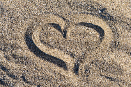 Heart shape and footprint on wet sand.の写真素材