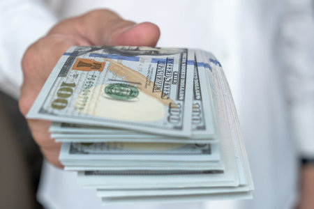Close up male hand Counting and holding money us dollar.