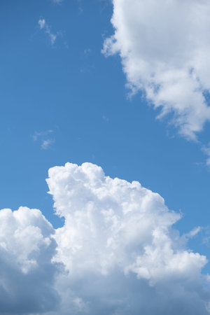 Big white clouds in a blue sky close-up. There is a place for the text