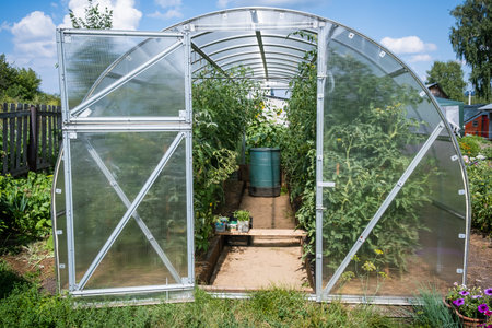 Greenhouse in the garden for growing tomatoes, cucumbers and plants.の写真素材