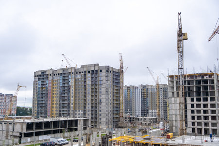 Builders work on large construction sites, and there are many cranes