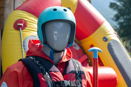 A mannequin in a red life jacket next to an inflatable boatの写真素材