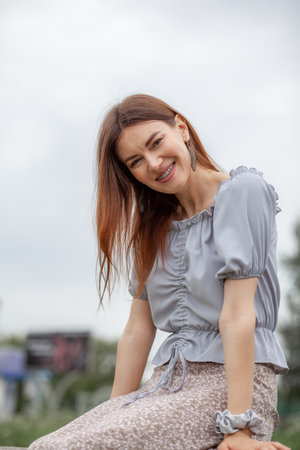 Smile of a young and beautiful girl with braces on her white teethの写真素材
