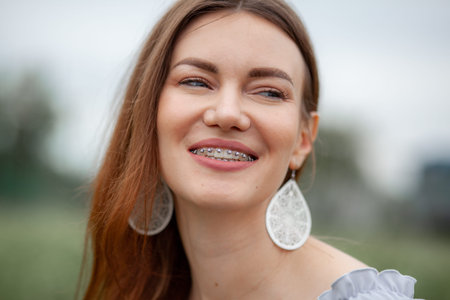 The smile of a young girl with braces on her white teeth.