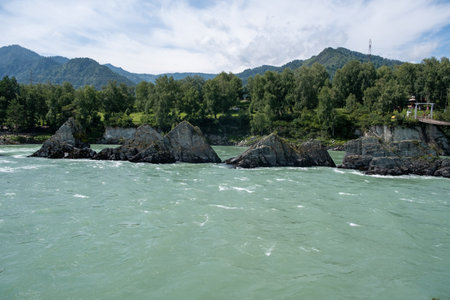 A wide, full-flowing mountain river with a fast current.の写真素材
