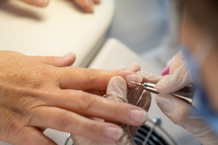 Female hands and tools for manicure, process of performing manicureの写真素材