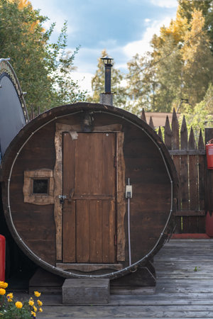 A round wooden bathhouse stands in the courtyard on a sunny summer dayの写真素材
