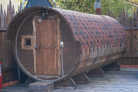 A round wooden bathhouse stands in the courtyard on a sunny summer dayの写真素材