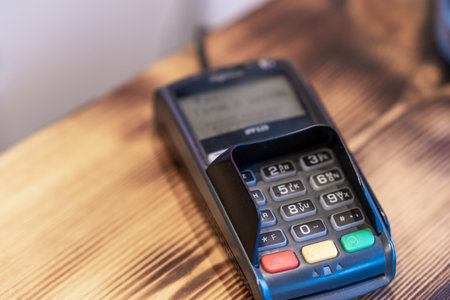 Terminal for cashless payment on a wooden background in a cafeの写真素材