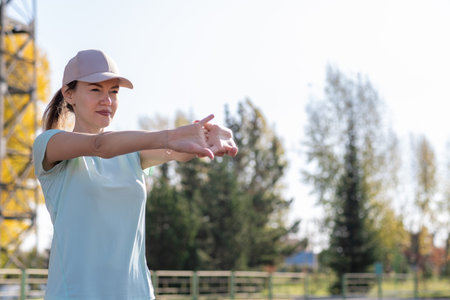 A young beautiful woman in sportswear plays sports at a local stadium