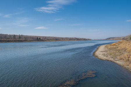Beautiful, wide autumn river among forests and rocky shore.の写真素材