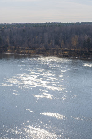 Beautiful, wide autumn river among forests and rocky shore.