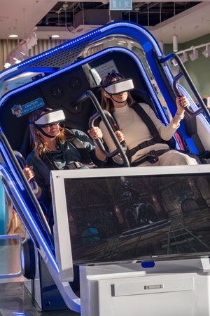 Two woman is sitting in an electric blue virtual reality chair