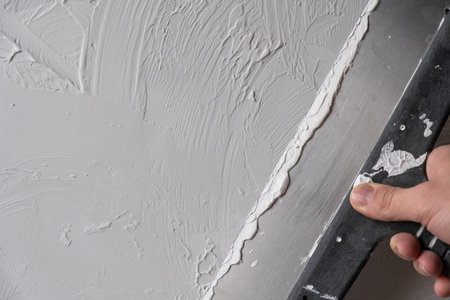Applying decorative putty. White abstract texture of surface covered with putty