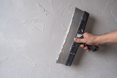 Applying decorative putty. White abstract texture of surface covered with puttyの写真素材