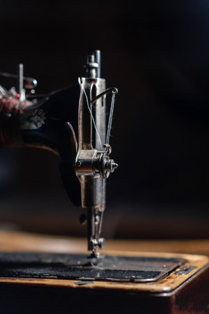 Old sewing machine stands on the table at home ready to work and sew.